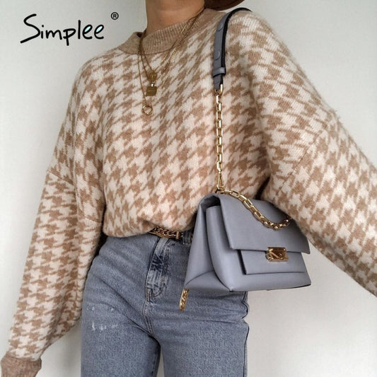 A woman wearing a beige and brown geometric knitted sweater with a round neckline, casual style suitable for autumn and winter.
